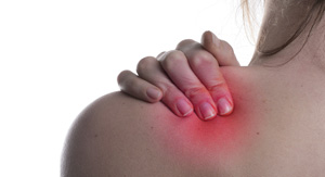 A photo of a woman holding her shoulder in pain.